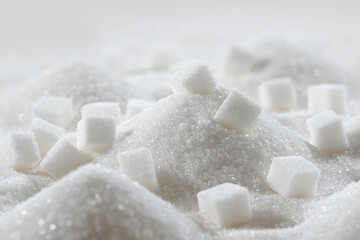 Fototapeta na wymiar White granulated sugar and refined sugar cubes close-up in the kitchen