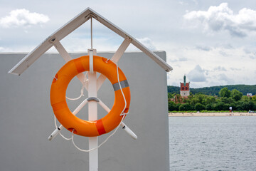 Orange lifebuoy at the beach, lifeguard float. lifeguard equipment, life saver or life ring. Concept of vacation and safety when swimming in the sea.