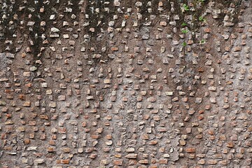 Many small stones in a concrete wall