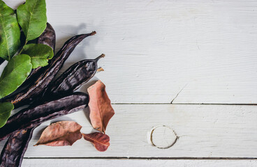 Carobs above a white wooden background