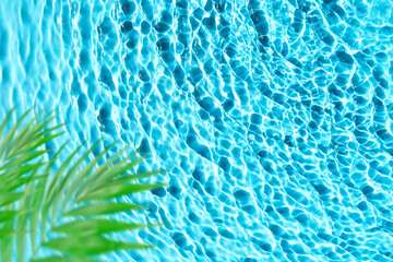 Beautiful tropical template with blue water texture background, water surface with sun rays reflection, palm leaves. High resolution.