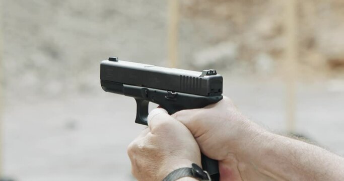 Pistol shooting bullets in slow motion footage. Hand guns in firing range