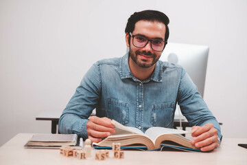 Confident entrepreneur, Joyful businessman reading book. Young male businessman reading books at workplace.