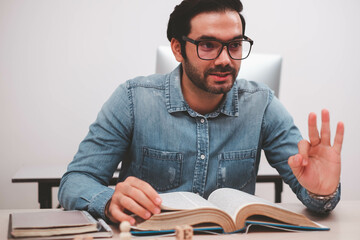 Confident entrepreneur, Joyful businessman reading book. Young male businessman reading books at workplace.