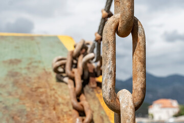 close-up of metal chains, rusty from salt water, attached to a fishing boat, rusty metal chains...