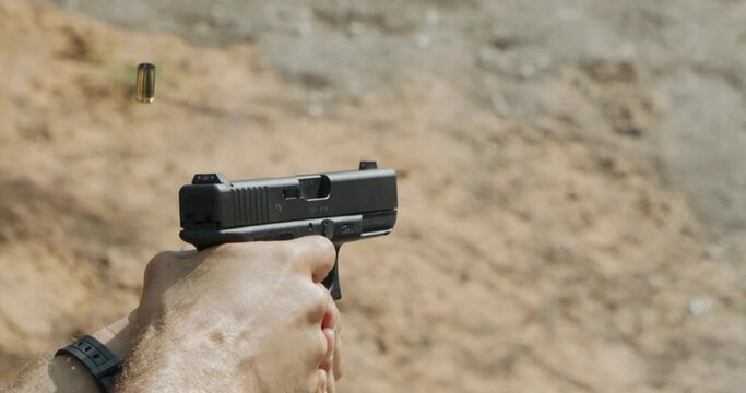 Pistol shooting bullets in super slow motion footage. Hand guns in firing range