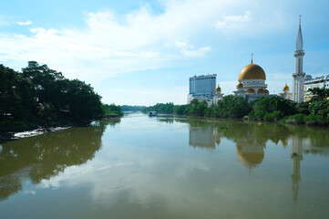 Fototapeta na wymiar Selective focus picture with noise effect Mosque with golden dome at Klang Riverside during daytime