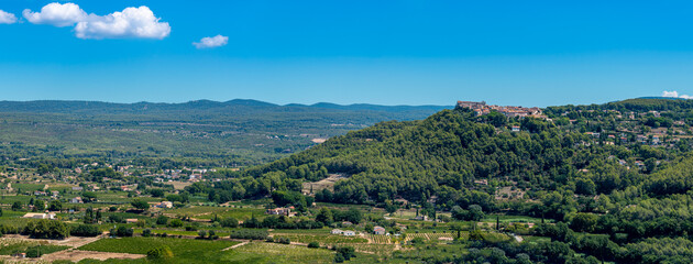 Fototapeta na wymiar Vue panoramique distante du village du Castellet, France, construit en haut d'une colline dominant la campagne environnante et les vignobles de Bandol, dans le département français du Var