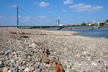 Climate change - the Rhine retreats and reveals an old rusty chain in Düsseldorf, Germany
