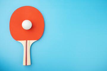 ping pong racket and ball on a blue background,copy space