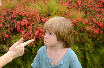 Female index finger. A little boy listens to his mother's instructions Angry mother is scolding at...