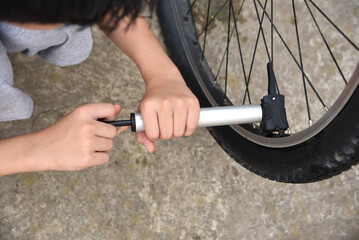 Men's Children's Hands Inflate Bicycle Wheel with Bicycle Pump Outdoors