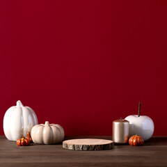 Empty wooden podium and ceramic pumpkin with golden candles for autumn product presentation