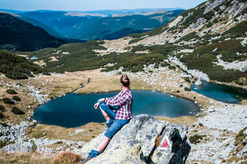 woman trekking in high mountains over glacier lake