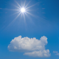 Naklejka na ściany i meble sparkle sun above dense cumulus clouds on blue sky background