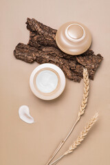 Flat lay composition with a moisturizer and autumn wheat spikelets, Natural nude, beige. Concept of protecting dry skin with cream in autumn