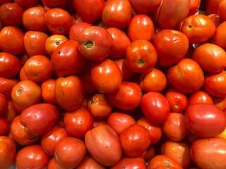 Close-up of a large number of round tomatoes placed together.