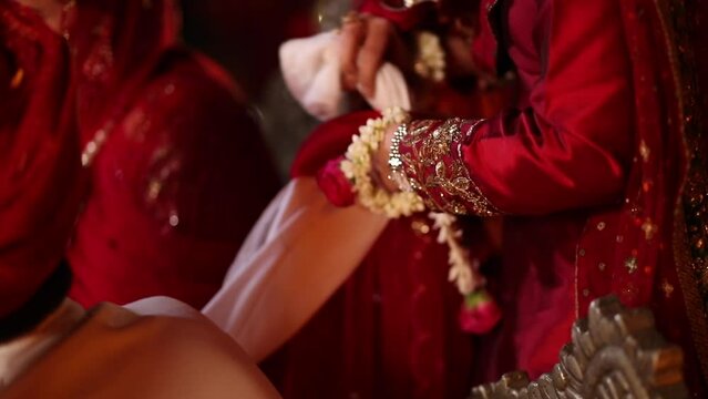 Shot of an Indian Groom's sister tying the marriage bandhan or wedding knot or jor bandhan in an Indian wedding