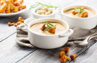 Mushroom Cream Soup with Shanterelles and Herbs, White Wooden Table