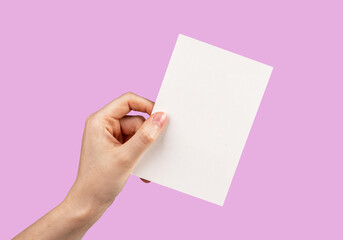 Obraz premium Hand holding card mockup on pink background. Template for congratulation, love confession, romantic letter. Valentines day greeting.