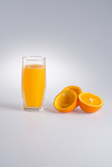 Glass of orange juice and  peel from orange on a white background