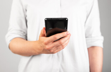Woman hand holding phone. Female using smartphone for reading news article or electronic book, browsing Internet. Frontal view