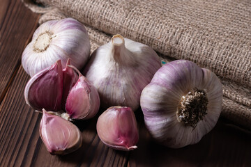 Garlic bulb on wooden background and sackcloth. Close up