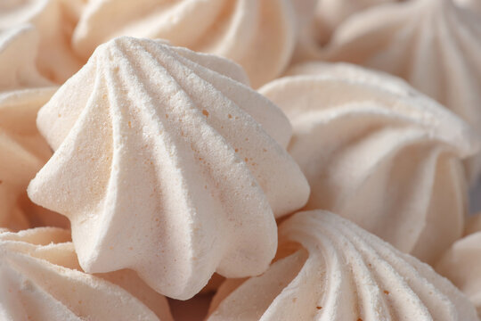 Small meringues in a white dish. Macro shot. Copy space