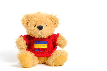 Soft toy on a white background, bear red jacket with flag Ukraine depicted on it.