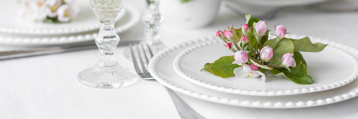 Beautiful table decor for a wedding dinner with a spring blooming apple tree flowers. Celebration...