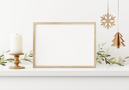 Brown horizontal wooden frame mockup in white interior with hanging Christmas decoration, candle and green plant garland. 3D rendering, illustration.