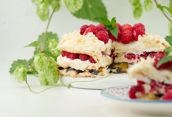 Round meringue pie with fresh raspberries on a white background, Pavlova dessert