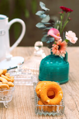 Mesa de café da manha com chá, flores e doces