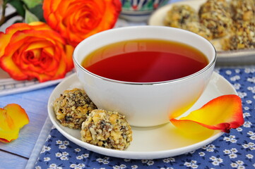 A white cup of tea and sweets on the table.