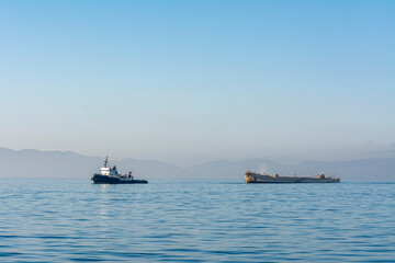 Tugboat towing scrap vessel