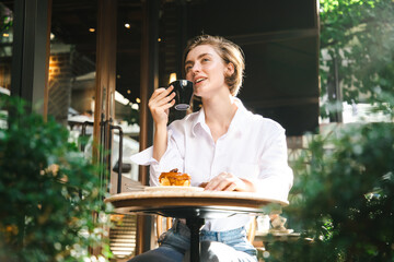 Shot of a beautiful young Asian woman drinking coffee at bakery cafe. Happy man drinking a cup of coffee at restaurant.