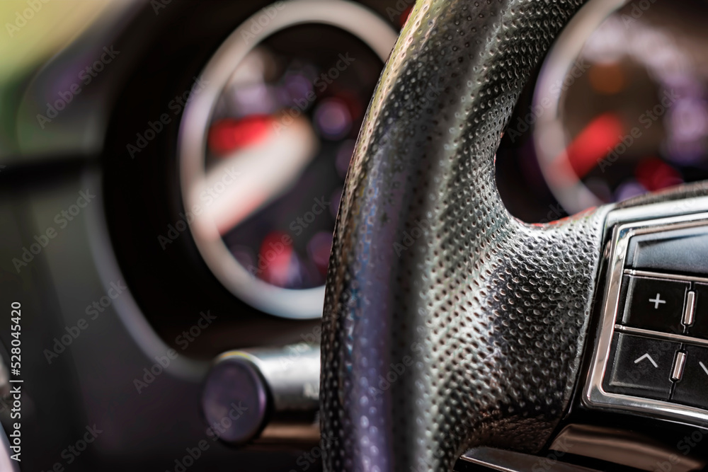 Poster close-up image of a car steering wheel with function buttons