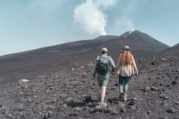 Couple hiking to a vulcanom the mount Etna.