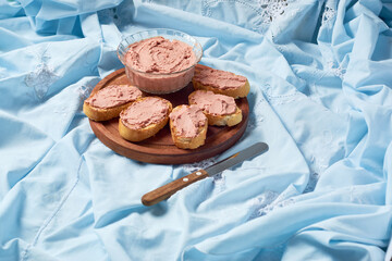 Homemade beef liver pate in a glass jar and baguette slices with pate