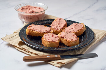 Bread toast with pork liver pâté on a rustic background.