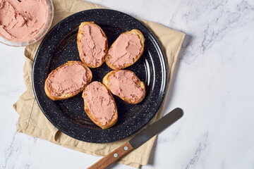 Bread toast with pork liver pâté on a rustic background.