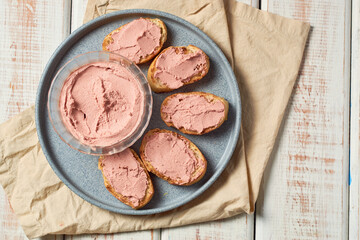 Bread toast with pork liver pâté on a rustic background.