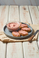 Homemade beef liver pate in a glass jar and baguette slices with pate