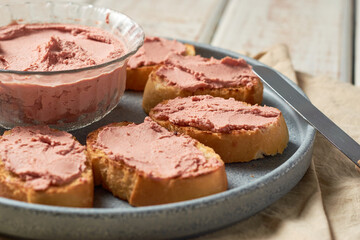 Bread toast with pork liver pâté on a rustic background.