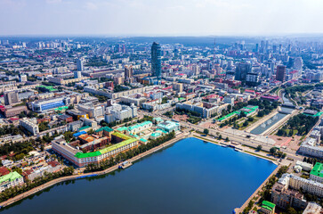 Aerial view of central part of modern city with skyscrapers and residential buildings. River and bridge on summer day.