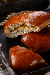 Close up of homemade buns with slices of apples inside on dark background.