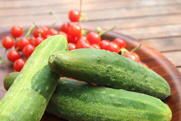 Some tiny cherry tomatoes and green peppers in white plates on wooden concept.