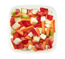 Chopped mix of vegetables in plastic container. Top view of raw vegetables isolated on white background. Preparing vegetables for freezing. Storage for winter storage in trays