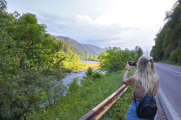 Naklejka na ściany i meble Girl takes picture of landscape with River Black Cheremosh in village of Krivorivnya, Ukraine