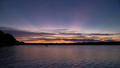 Fototapeta na wymiar Dawn colors in clouds over lake